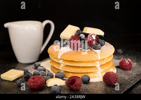 Frittelle con frutti di bosco, cioccolato bianco e crema di latte Foto Stock