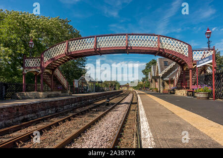 Guardando verso il basso la piattaforma e i binari ferroviari di Kirkby Stephen su una bella giornata estiva, Yorkshire Dales Foto Stock