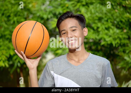 Felice maschile giovane giocatore di pallacanestro con basket Foto Stock