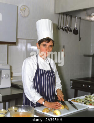 Femmina di lavoro dello chef in cucina, Guildford, Surrey, England, Regno Unito Foto Stock