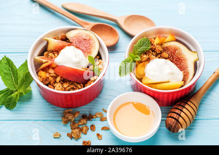 Muesli con frutta e yogurt greco su sfondo blu. Primo piano. Sana colazione o uno spuntino cibo Foto Stock