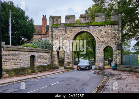 Priory Arch cancello vicino la Cattedrale di Lincoln, Lincolnshire nero con un VW Passat guidando attraverso di esso e pedonale per lato Foto Stock