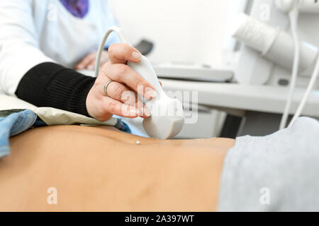 Close-up medico esegue la diagnostica ad ultrasuoni dei pazienti addome e degli organi interni. Foto Stock