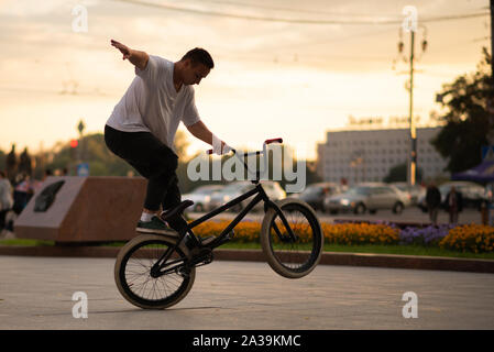 Il ragazzo esegue uno stunt su BMX, in piedi sulla ruota posteriore. Foto Stock