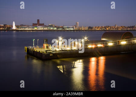 Woodside ferry terminal in Birkenhead illuminata di notte, con il Liverpool skyline della città attraverso il fiume Mersey Foto Stock