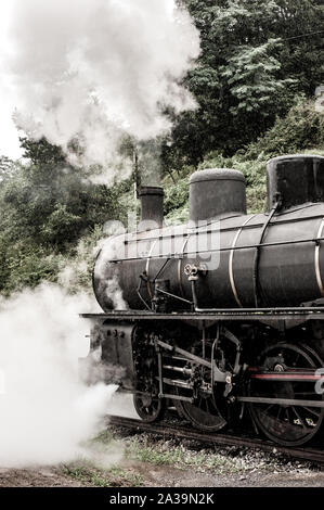 Lo spostamento del treno a vapore puffing fumo denso in aria Foto Stock