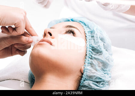 Modello nel cappuccio per capelli guardando al master di ciglia Foto Stock