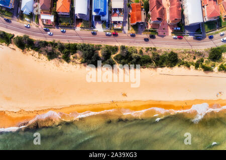 Facciate di case residenziali rivolta Umina beach in Woy Woy città di Central Coast in Australia. Antenna vista dall'alto in basso su una vasta spiaggia di sabbia e esp Foto Stock