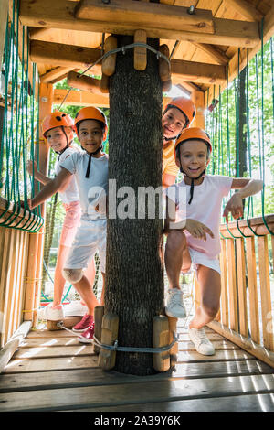 Felici i bambini multiculturale in caschi sorridere mentre guardando la fotocamera Foto Stock