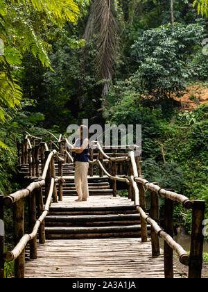 Giovani moda donna su un ponte di bambù Foto Stock