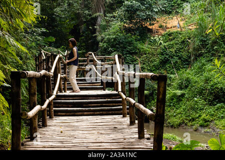 Giovani moda donna su un ponte di bambù Foto Stock