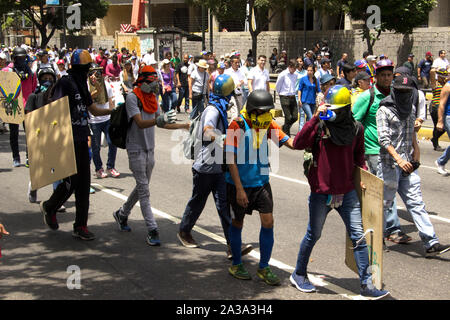 I manifestanti che partecipano all'evento chiamata la madre di tutte le proteste in Venezuela contro Nicolas Maduro il governo indossando anti gas lacrimogeni maschere Foto Stock