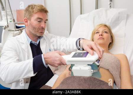 Attenzione giovane medico mediante macchina ad ultrasuoni in ospedale Foto Stock