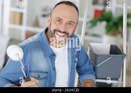 Uomo felice tiene un rullo a casa Foto Stock