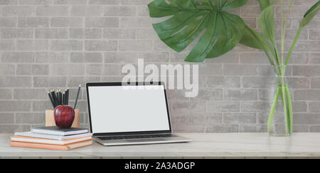 Loft con area di lavoro aprire schermo vuoto workplace con forniture da ufficio e di albero pot su grigio Sfondo mattone Foto Stock
