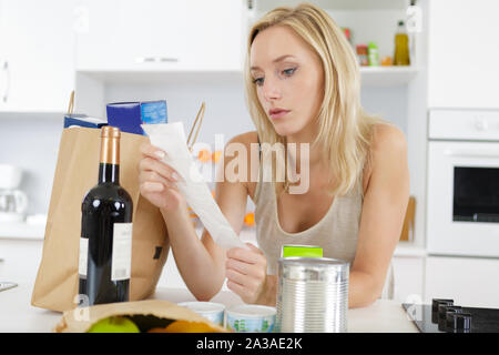 Una donna sta controllando la lista della spesa Foto Stock