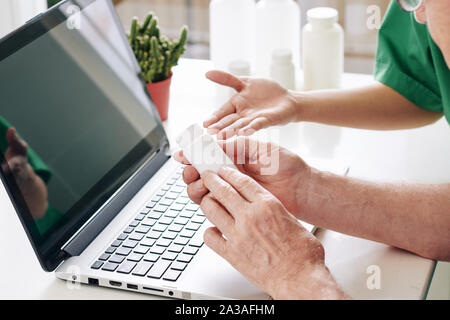 Close-up immagine del medico spiegando senior prescrizione del paziente e come prendere pillole e forniture Foto Stock