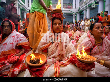 Kolkata, India. 06 ott 2019. Indian donne indù di sedersi con fuoco ardente pentole sulle loro mani e testa come parte della loro pratica rituale che include la cieca fede e superstizione per superare ogni difficoltà nel prossimo futuro durante il Maha ashtami celebrazione il giorno 8 di Durgapuja.Durgapuja è il più grande festival indù acceso per 9 giorni in tutta l India. Credito: SOPA Immagini limitata/Alamy Live News Foto Stock