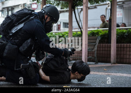 Hong Kong, Cina. 06 ott 2019. Un funzionario di polizia che gestisce una vernice spray barattolo appartenenti al manifestante arrestato durante la dimostrazione.i manifestanti hanno marciato attraverso vari distretti di Hong Kong nell'ultimo round di proteste. Mentre la dimostrazione ha iniziato pacificamente, polizia arrivati più tardi per condurre una operazione di dispersione risultante in molti arresti. Governo anti-manifestanti continuano a fare la loro "5 richieste" sentito come loro continuano a sfidare il governo e polizia avvisi settimana dopo settimana. Credito: SOPA Immagini limitata/Alamy Live News Foto Stock