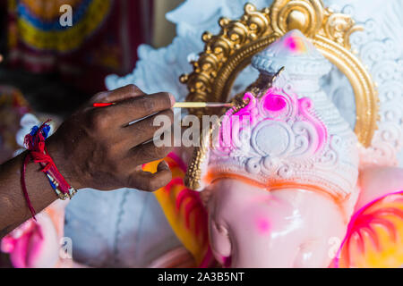 Uomo indiano che decora l'idolo di Ganesh per il festival di Chaturthi di Ganesh in India di Mumbai Foto Stock