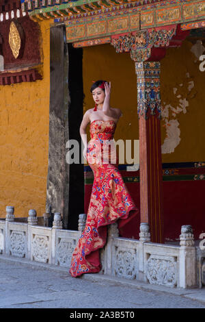 Un giovane cinese Han pone la donna per il suo ritratto di nozze presso il Palazzo Norbulingka, l'ex palazzo estivo del Dalai Lama a Lhasa, in Tibet. Foto Stock