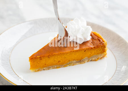 Fetta di vegan in casa torta di zucca con vegane di panna montata Foto Stock