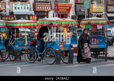 Un pedicab è un economico sotto forma di trasporto a Lhasa, in Tibet. Foto Stock