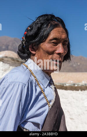 Un tibetano buddista uomo dal Kham regione del Tibet orientale su un pellegrinaggio al palazzo del Potala a Lhasa, in Tibet, indossando un tradizionale copricapo. Foto Stock