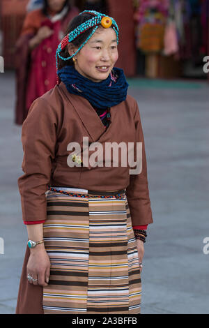 Un giovane Khamba donna tibetana del Kham regione del Tibet orientale su un pellegrinaggio per visitare luoghi santi in Lhasa, in Tibet. Indossa una tradizionale Foto Stock