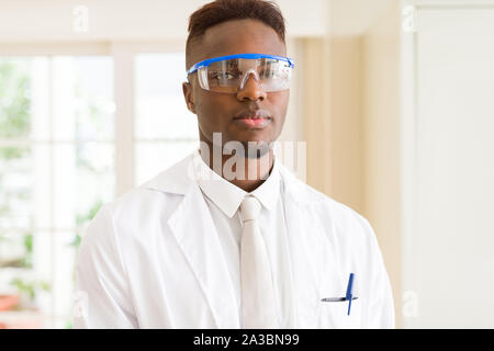 Africa scienziato giovane uomo che indossa gli occhiali di sicurezza lavorando con apparecchiature chimiche Foto Stock