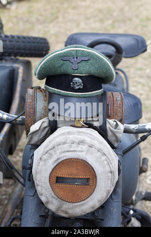 WW2 tedesco Waffen SS visiera berretto con eagle e il cranio insegne su una motocicletta BMW Foto Stock
