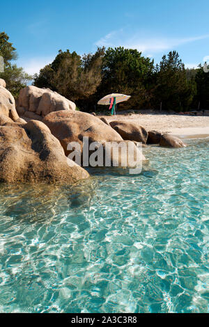 Appartato acqua limpida, spiaggia di sabbia bianca e rocce con ombrellone / Plage de Santa Giulia / spiaggia di Santa Giulia, Porto-Vecchio Corsica spiaggia estiva Foto Stock