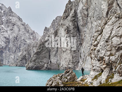 L'uomo con la fotocamera tenendo fotografia di montagna lago Kel Suu vicino al confine cinese in Kirghizistan Foto Stock