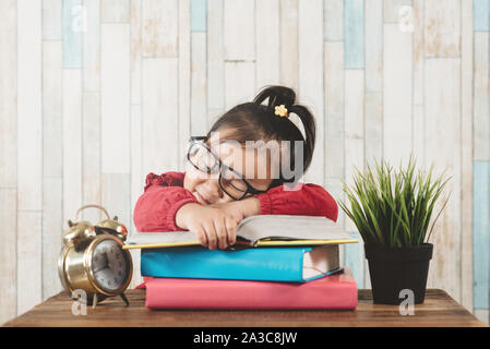 Incantevole piccola ragazza asiatica si addormentano mentre studiava. Concetto di istruzione e stanchezza Foto Stock