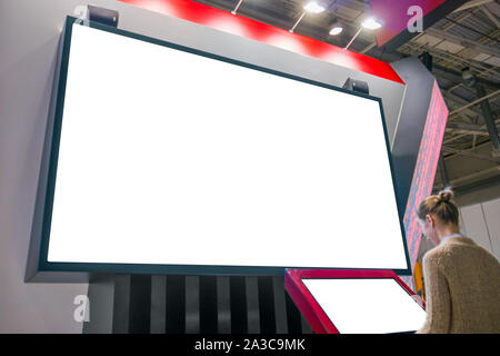 Mockup immagine - donna guardando il vuoto bianco parete grande display Foto Stock