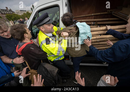 Estinzione della ribellione manifestanti lotta per impedire la loro van attrezzatura essendo confiscati dalla polizia nel corso di una occupazione di Westminster Bridge. Il attivisti ambientali iniziano due settimane di nuova ondata di azione di protesta causando interruzioni presso i siti principali di Londra incluso Westminster Bridge, Lambeth Bridge, Trafalgar Square, il Parlamento aree e Smithfield Market nonché di numerosi blocchi stradali. La Metropolitan Police hanno confermato oltre 1500 arresti per data. Londra, Regno Unito. Foto Stock