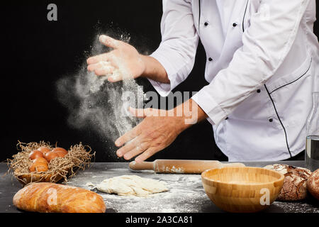 Close up di un irriconoscibile baker scattering farina sopra puffy pastella mentre rendendo pane tradizionale, spazio di copia Foto Stock