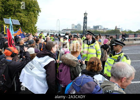 Westminster, London, Regno Unito - Lunedì 7 Ottobre 2019 - estinzione della ribellione XR clima manifestanti e forze di polizia il blocco ingresso Nord di Lambeth Bridge a Westminster - Photo Steven Maggio / Alamy Live News Foto Stock