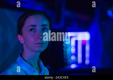 Giovane donna guardando intorno al moderno salone coinvolgente Foto Stock