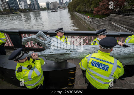 Londra, Regno Unito. Il 7 ottobre, 2019. La polizia grippare di parti del corpo di un gigante metallica di figura dalla ribellione di estinzione manifestanti durante una professione di Lambeth Bridge. Il attivisti ambientali iniziare una nuova ondata di azione di protesta questa mattina causando interruzioni a Londra. La Metropolitan Police ha confermato 21 arresti finora questa mattina. Credito: Guy Corbishley/Alamy Live News Foto Stock