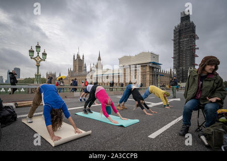 Estinzione della ribellione mattina sessioni di yoga su un occupato Westminster Bridge. Il attivisti ambientali iniziano due settimane di nuova ondata di azione di protesta causando interruzioni presso i siti principali di Londra incluso Westminster Bridge, Lambeth Bridge, Trafalgar Square, il Parlamento aree e Smithfield Market nonché di numerosi blocchi stradali. La Metropolitan Police hanno confermato oltre 1500 arresti per data. Londra, Regno Unito. Foto Stock