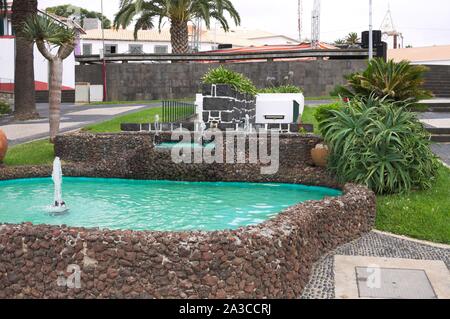 Una fontana in un giardino tropicale con piante e vasi (Porto Santo, Madeira, Portogallo) Foto Stock