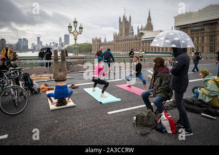 Estinzione della ribellione mattina sessioni di yoga su un occupato Westminster Bridge. Il attivisti ambientali iniziano due settimane di nuova ondata di azione di protesta causando interruzioni presso i siti principali di Londra incluso Westminster Bridge, Lambeth Bridge, Trafalgar Square, il Parlamento aree e Smithfield Market nonché di numerosi blocchi stradali. La Metropolitan Police hanno confermato oltre 1500 arresti per data. Londra, Regno Unito. Foto Stock