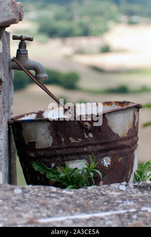 Rusty bucket di un vecchio vintage rubinetto esterno senza acqua. per mancanza di acqua.la mancanza di risorse idriche Foto Stock