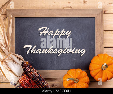 Felice ringraziamento testo scritto su una lavagna con colorati mini Zucche e mais indiano Foto Stock