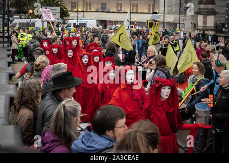 Estinzione Rebellion " Red Rebel Brigata" Unisciti al cambiamento climatico attivisti su Lambeth Bridge indossando il loro marchio rosso sangue per gli abiti. Londra, Regno Unito. Foto Stock