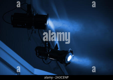 Due blu luci spot con smoky raggi montati in camera oscura, stadio di apparecchiature di illuminazione Foto Stock