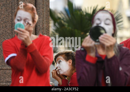 Membri del 'Rosso Brigata" entrare in costume e applicare il make-up per un'estinzione della ribellione protesta in Westminster, Londra. Foto Stock