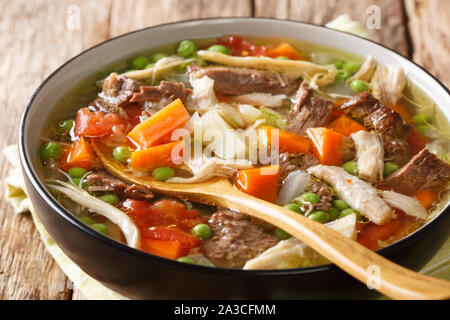 Spesso cotte lentamente la zuppa a base di verdure e carne di close-up in una piastra sul tavolo orizzontale. Foto Stock