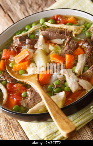 Slow Cooker Booyah belga zuppa di verdure e carne di close-up in una ciotola sul piano verticale. Foto Stock